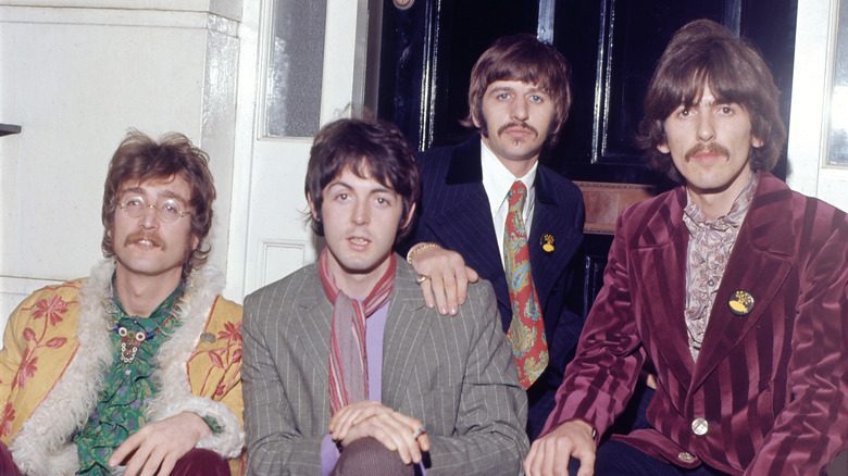 The Beatles kneeling on doorstep
