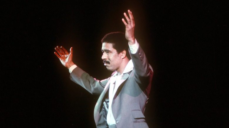 Richard Pryor sur scène avec les mains levées