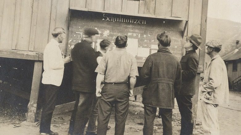 German prisoners reading a notice board