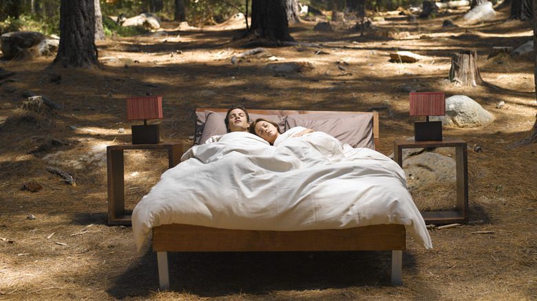Couple dormant dans un lit en pleine nature