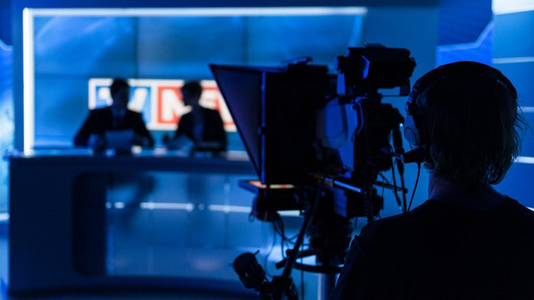 Newscasters filmed in darkness