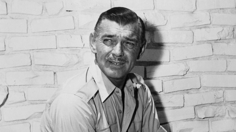Clark Gable squinting brick wall background
