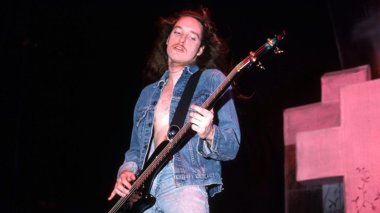 Cliff Burton jouant de la basse avec une veste en jean