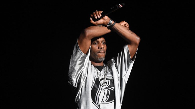 DMX les bras levés tenant un micro