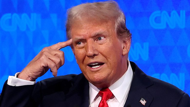 Donald Trump points at head