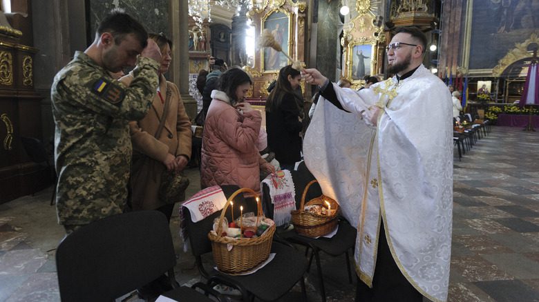 Un prêtre catholique ukrainien bénissant des paniers de Pâques pour des soldats