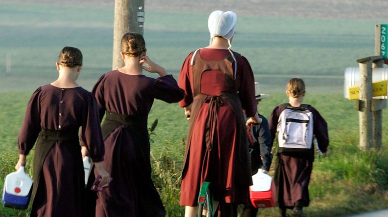 femme amish conduisant des enfants à l'école