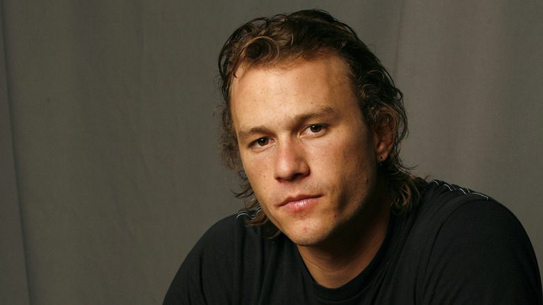 Heath Ledger en chemise noire regardant fixement