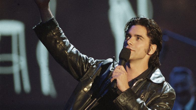 John Stamos is black leather jacket with microphone