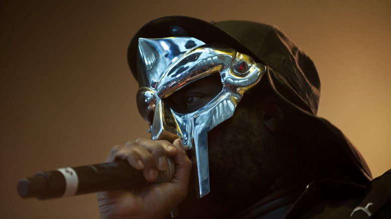 MF DOOM avec un masque, une capuche et un micro