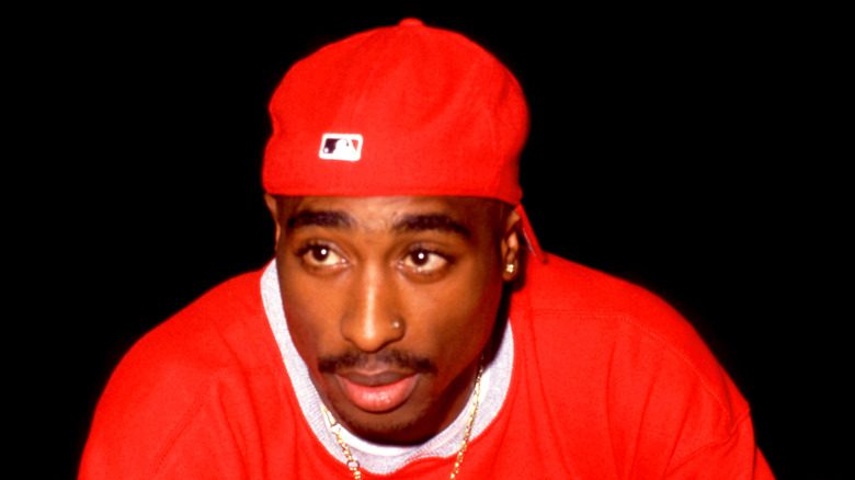 Tupac Shakur en casquette et chemise rouges