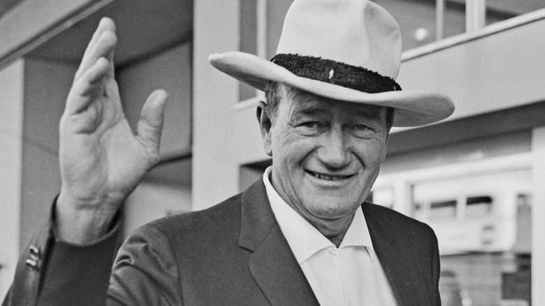 John Wayne sourit et salue