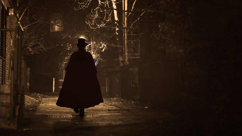 silhouette d'une figure mystérieuse marchant dans une rue, portant une cape