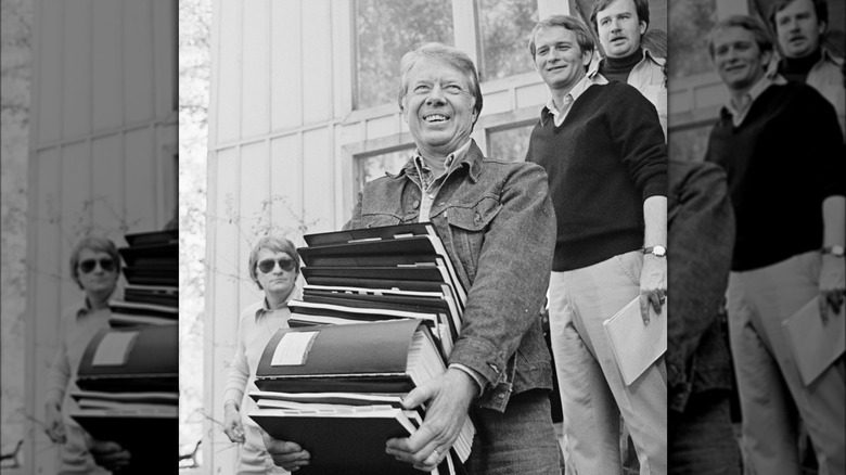 Jimmy Carter souriant en tenant des dossiers