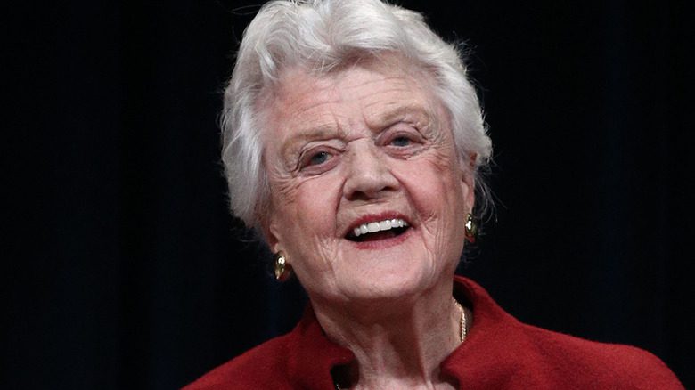 Angela Lansbury riant sur fond noir