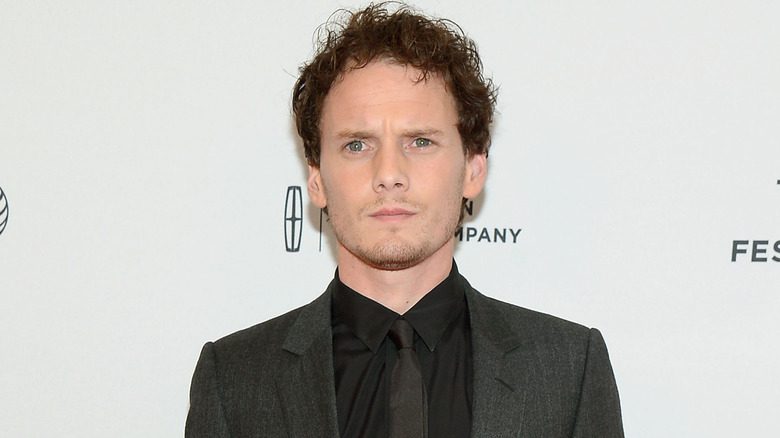 Anton Yelchin en costume noir avec une cravate à un événement