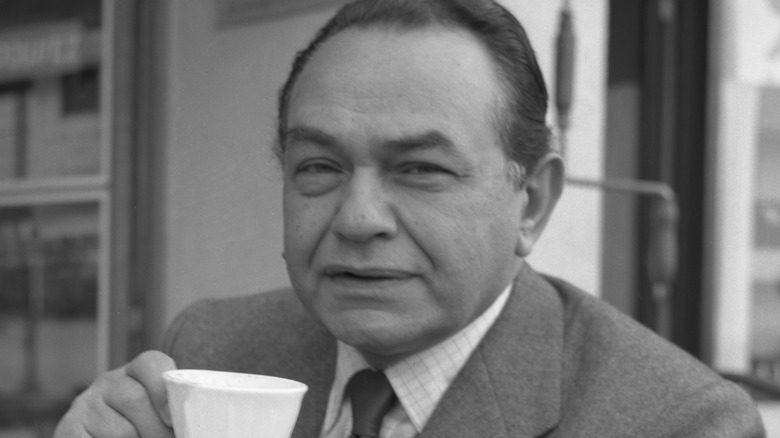 Edward G. Robinson tenant une tasse en plissant les yeux