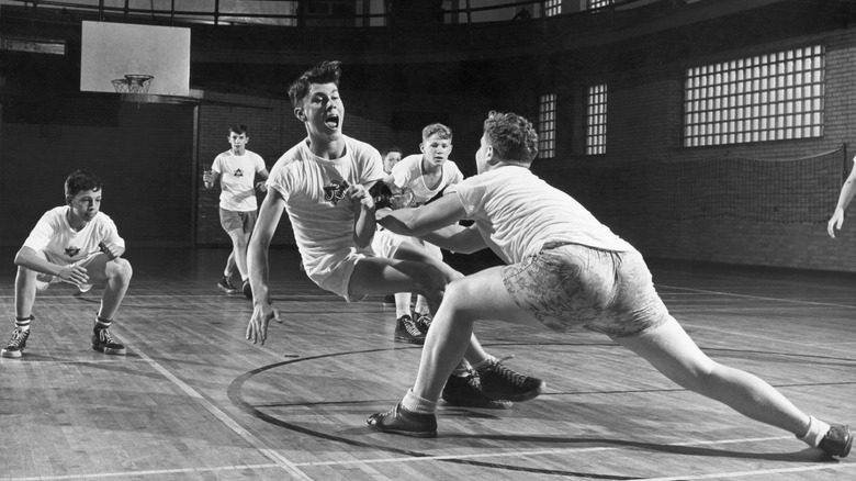 Jeu de basket-ball précoce avec des joueurs tombant à la YMCA