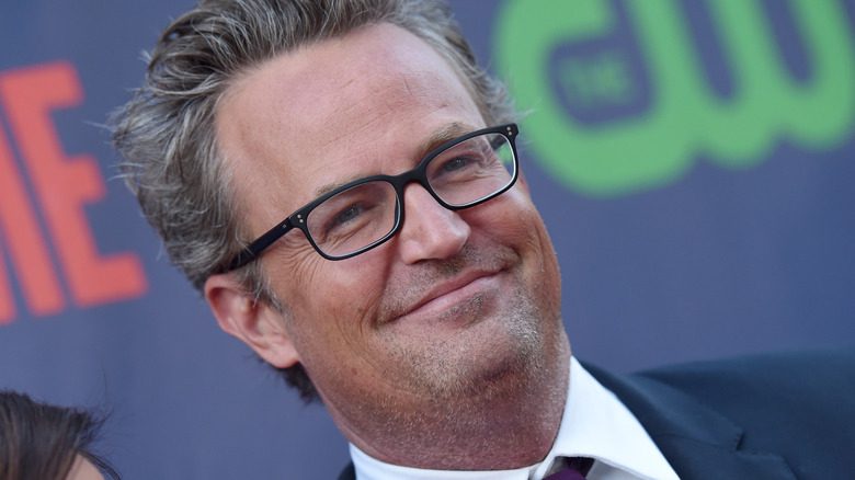 Matthew Perry souriant avec des lunettes