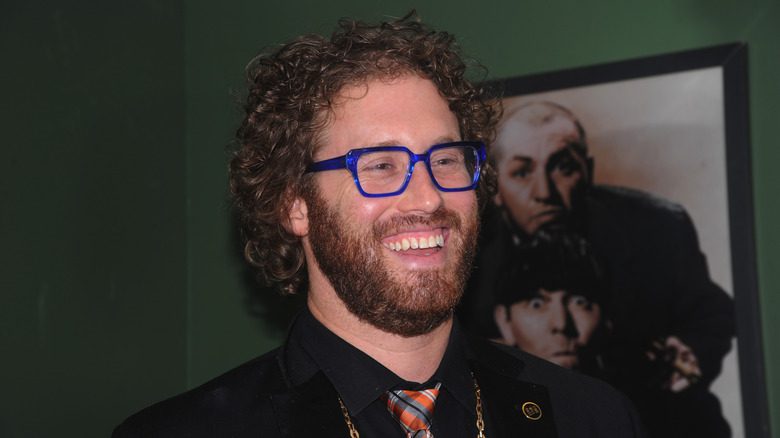 T.J. Miller avec des lunettes bleues souriant