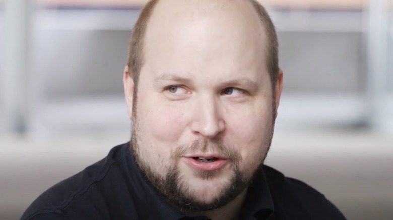 Markus Persson parlant en regardant au loin