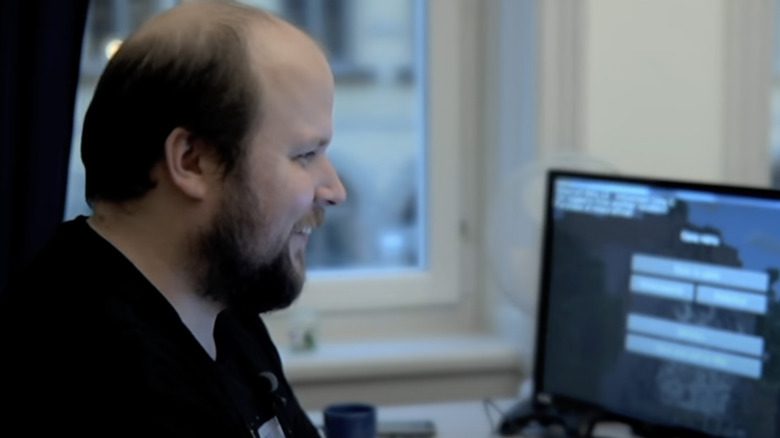 Markus Persson codant en souriant