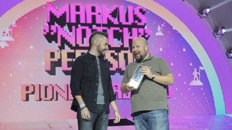 Markus Persson souriant avec un prix