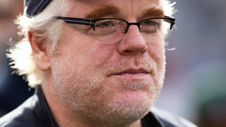 Philip Seymour Hoffman with glasses and baseball cap.