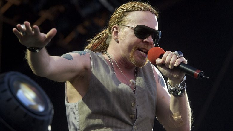 Axl Rose lunettes de soleil dreadlocks chantant sur scène