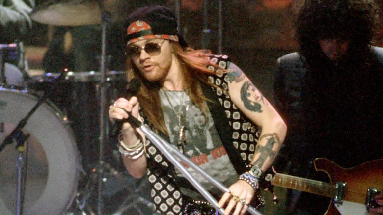 Axl Rose sunglasses black cap singing