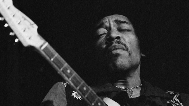 Jimi Hendrix performing with guitar