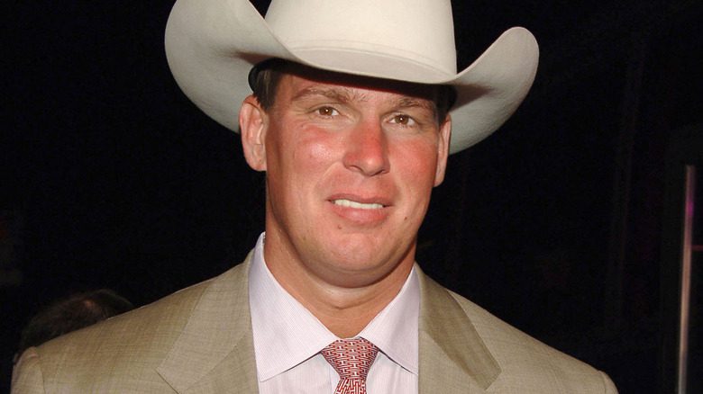 JBL souriant dans un costume beige et un chapeau blanc