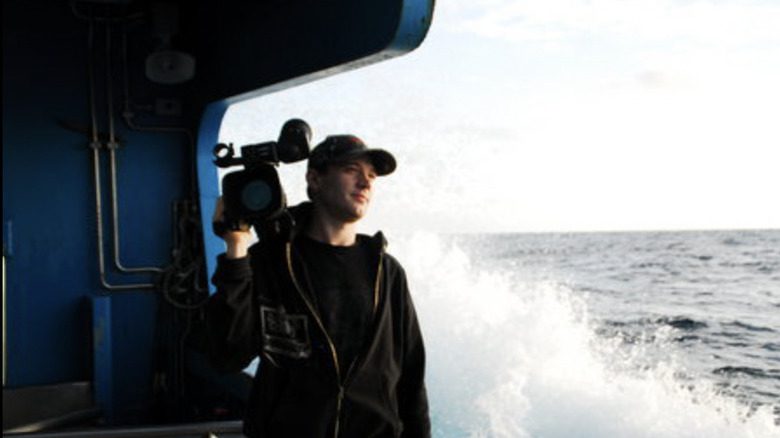 Lee Grivas sur un bateau avec une caméra