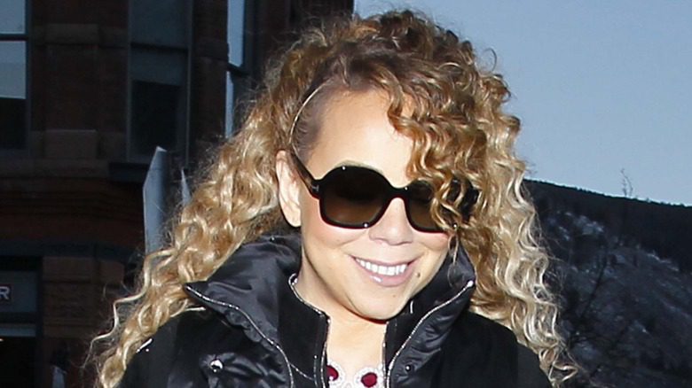 Mariah Carey grimçant avec des lunettes de soleil en regardant vers le bas