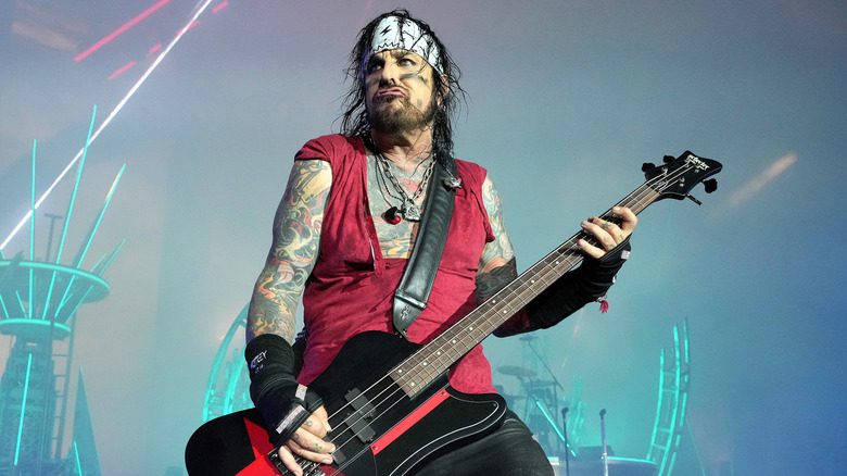 Nikki Sixx avec un bandana jouant de la basse sur scène