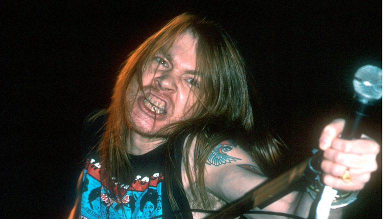 Axl Rose tenant un microphone et serrant les dents