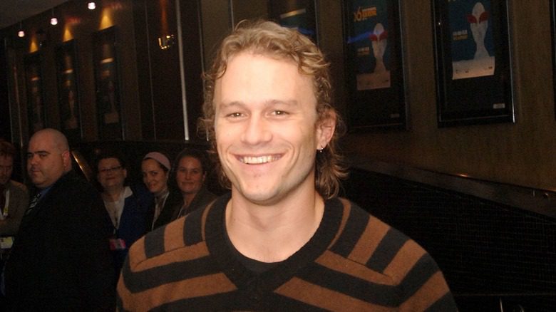 Heath Ledger penchant une chemise rayée souriant à un événement