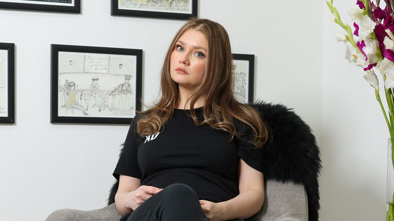 Anna Delvey assise dans son appartement