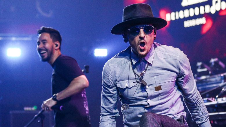 Chester Bennington portant un chapeau et des lunettes, s'amusant sur scène