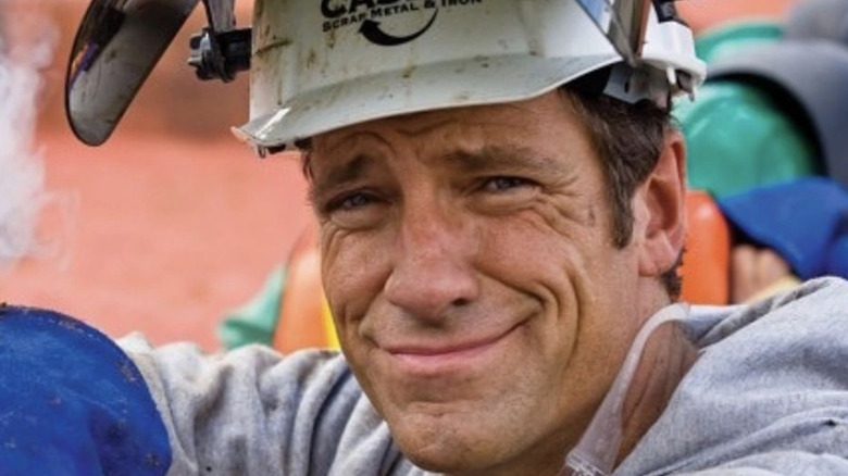 Mike Rowe grimace dans des vêtements sales avec un équipement de protection