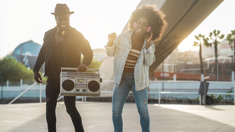 Un homme et une femme dansant avec une boombox