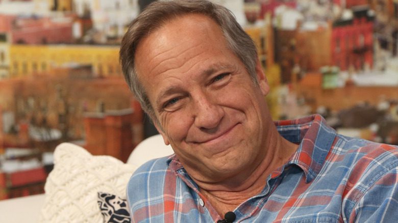 Mike Rowe s'appuyant sur un canapé, chemise à carreaux