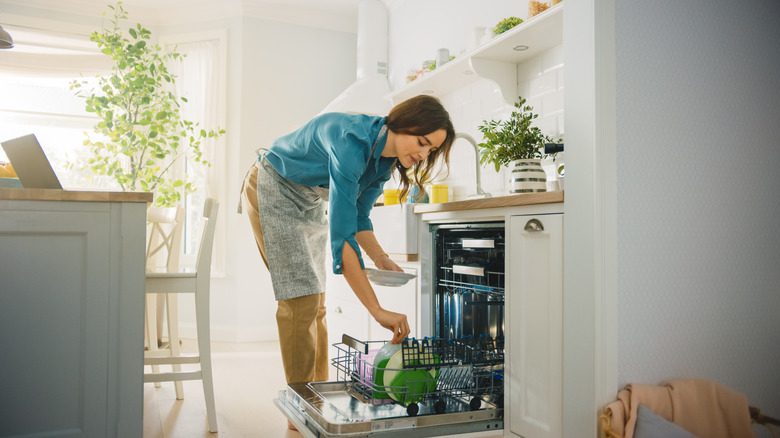 femme utilisant un lave-vaisselle