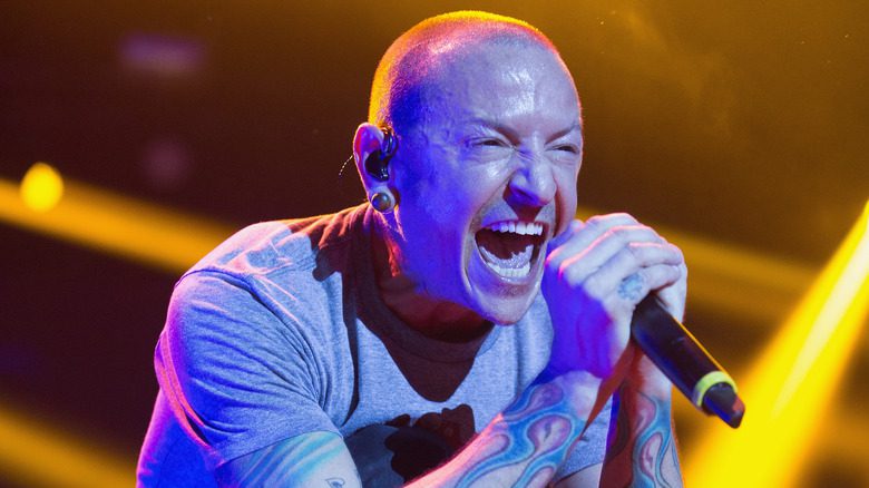 Linkin Park's Chester Bennington screaming into the microphone on stage