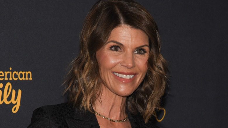 Lori Loughlin regardant au loin, dents serrées