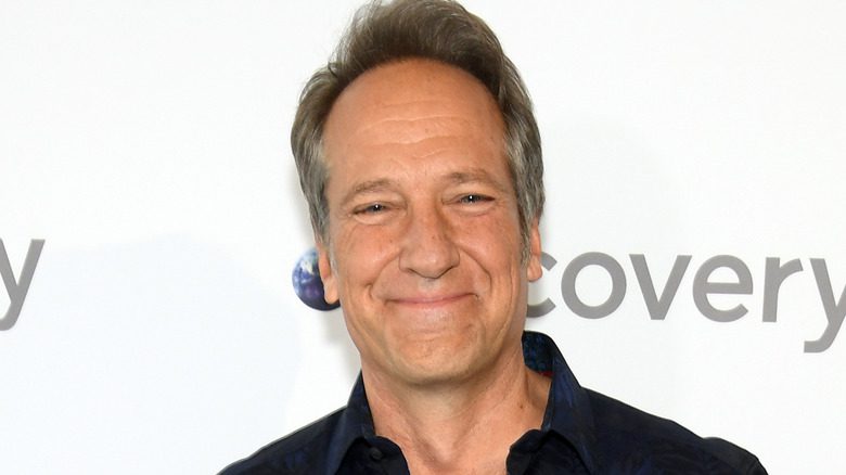 Mike Rowe avec un sourire à l'arrière-plan de Discovery