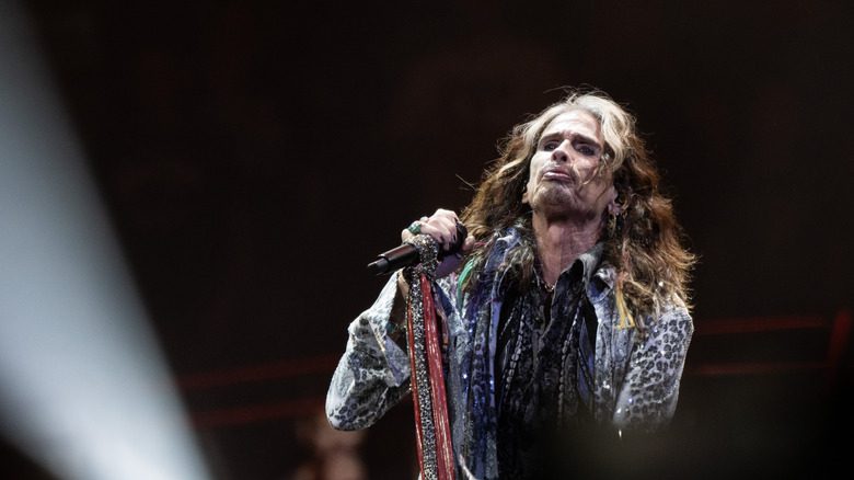 Steven Tyler tenant un micro, la tête inclinée