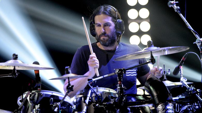 Rob Bourdon portant des écouteurs et jouant de la batterie