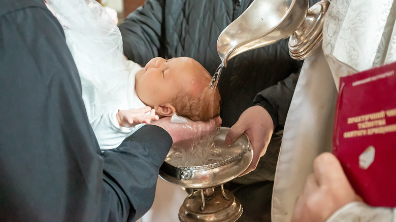 un bébé est baptisé