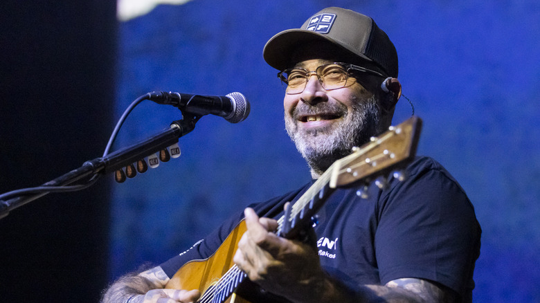 Aaron Lewis jouant de la guitare et souriant en concert